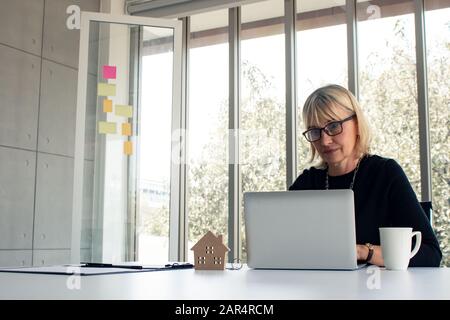 Women are thinking about planning a project of house. Senior women are seeking information about a House on the computer. Female staring at a computer Stock Photo