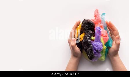 Woman hands holding a colored plastic bags in ball composition Stock Photo