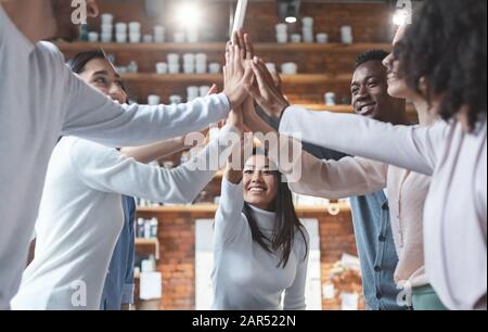 Young international business team giving high five in office Stock Photo