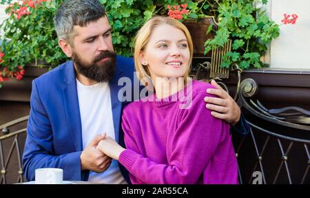 Couple in love sit cafe terrace enjoy coffee. Pleasant family weekend. Married lovely couple relaxing together. Travel and vacation. Explore cafe and public places. Couple cuddling cafe terrace. Stock Photo