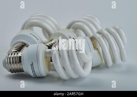 Four old white halogen spiral lamps lie on a table. on white isolated background Stock Photo