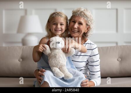 Different generations female family wearing crowns, portrait. Stock Photo