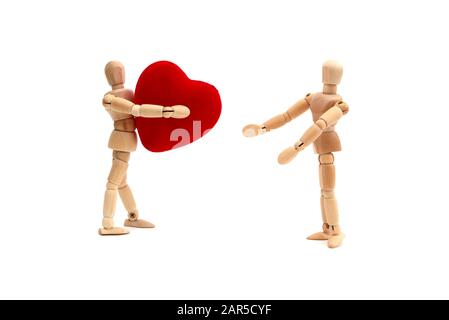 Two wooden dolls holding a heart against a white background Stock Photo