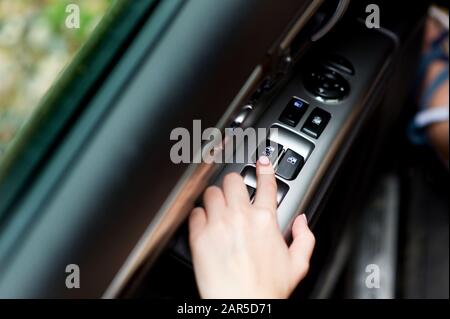 hand using electronic power windows in a car Stock Photo