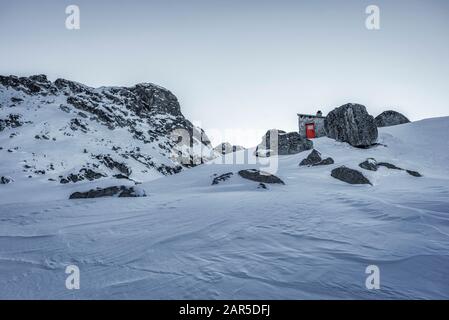 Scary lake shelter at winter in front of frozen lake in Rila mountain national park, Bulgaria Stock Photo
