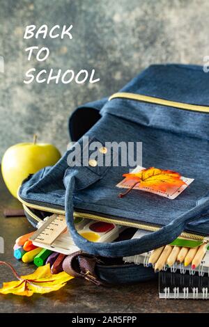 Back to school concept. School supplies with blue backpack on table. Stock Photo