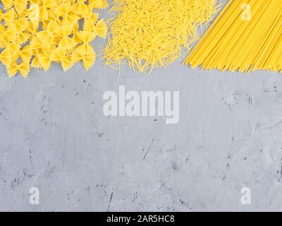 Three types of pasta on a gray concrete background. Healthy eating concept Stock Photo