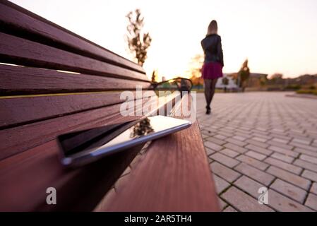 Forgotten smartphone on a park bench. Stock Photo
