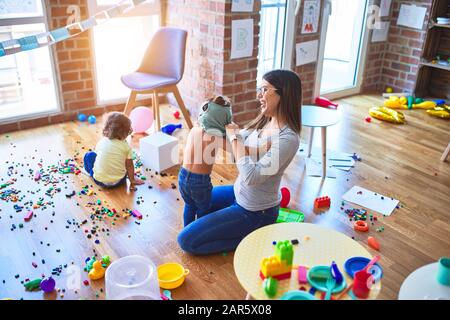 Young beautiful teacher and toddlers playing at kindergarten Stock Photo