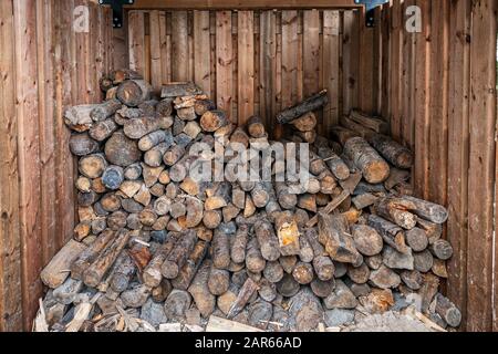 Pile of firewood in wooden storage shelter Stock Photo