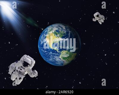 Two astronauts in outer space with Planet Earth. Elements of this image furnished by NASA. Stock Photo