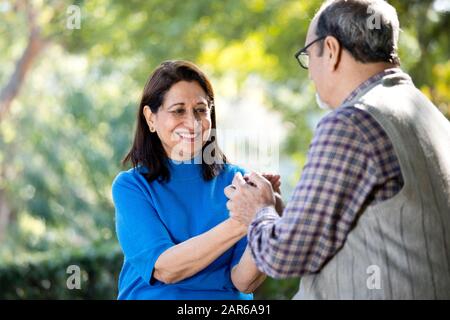Happy senior couple holding hands at park Stock Photo