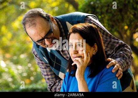 Man comforting senior woman at park Stock Photo