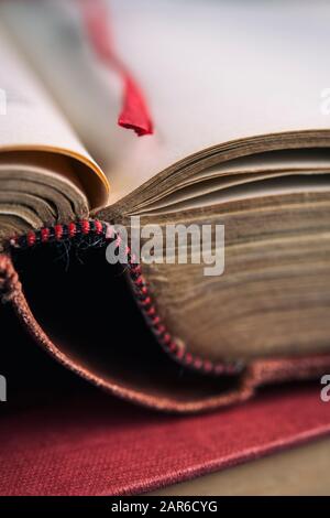 Antique book opened at a page with a red ribbon bookmark Stock Photo