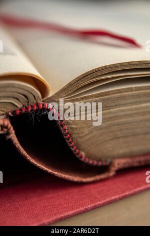 Antique book opened at a page with a red ribbon bookmark Stock Photo