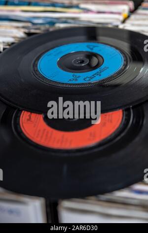 Two seven inch vinyl singles from the 1980s on top of a collection of  records Stock Photo