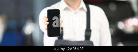 Male in working clothes showing gadget Stock Photo