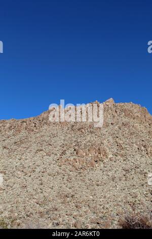 Below the deep blue Southern Mojave Desert sky rises ridges bounding Rattlesnake Canyon of Joshua Tree National Park. Stock Photo