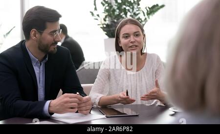 Young confident female manager asking questions explaining project ideas. Stock Photo