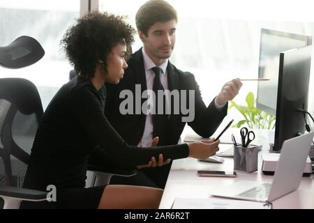 Motivated diverse employees working on business analytics project in office. Stock Photo