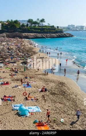 CANARY ISLAND TENERIFE, SPAIN - 27 DEC, 2019: Tourits walking on the boardwalk along Playa El Duque. It’ one of the most popular beaches on Tenerife. Stock Photo
