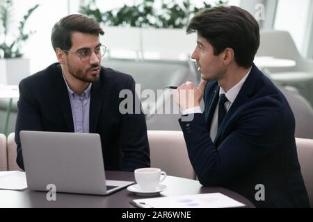 Two business partners discussing project financial results in modern office. Stock Photo