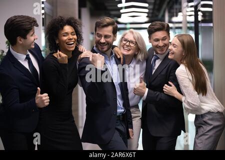 Happy multiracial different ages employees celebrating successful project finish. Stock Photo