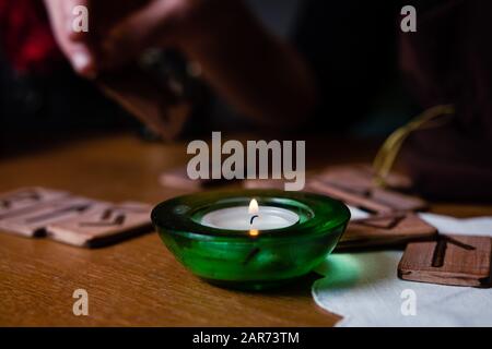 Hands of a mature woman hold runes. Fortune telling on the runes Stock Photo