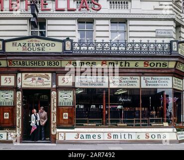 London 1970s, elegant couple shopping, James Smith & Sons umbrella and stick store, New Oxford street, England, UK, GB, Great Britain, Stock Photo