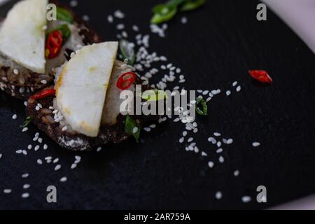 Mini sandwich with radish, black bread, chili pepper, sesame seed. Stock Photo