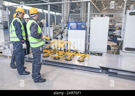 Group of workers and business man at facroty, permanent electro magnets for lifting steel plate, industrial lifting magnets, sheet lifting magnet load Stock Photo