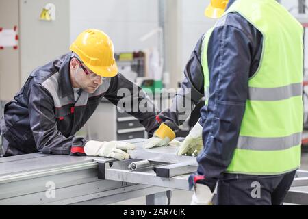 Turner is working on the machine metal processing lathe group of workers at cnc factory Stock Photo