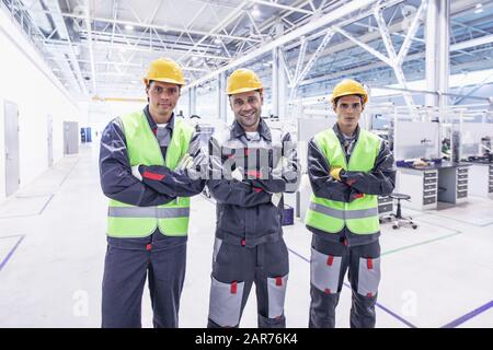 Portrait of three workers at factory teamwork cooperation concept Stock Photo