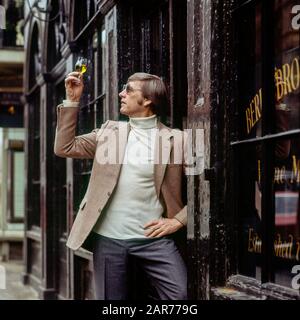 London 1970s, man examines a sherry wine glass outside Berry Bros. & Rudd wine merchants store, St James street, England, UK, GB, Great Britain, Stock Photo