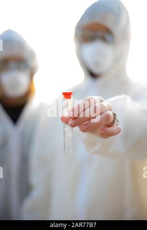 Female scientists holding water sample at beach Stock Photo