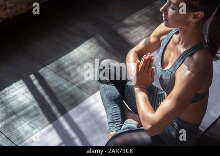 Calm fit healthy woman sit in lotus pose do yoga meditate indoor, closeup view Stock Photo