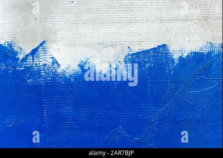 the texture of the gray draft wall, which is half painted with bright blue paint with an inaccurate transition from the painted surface to the unpaint Stock Photo