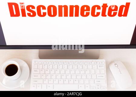 computer monitor with "Disconnect" text displayed Keyboard, mouse, coffee. Concept, No connection, system error Stock Photo