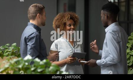 Multiethnic coworkers talk discussing business ideas in office Stock Photo