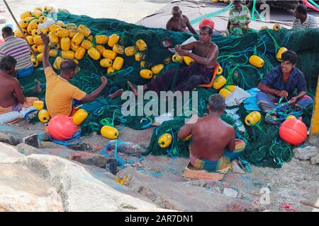 Fishermen mending their nets in Mirissa Harbour Stock Photo