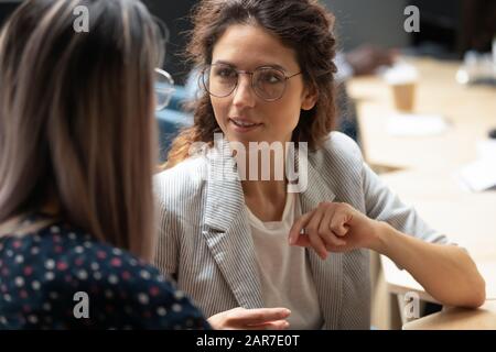 Close up of female employee talk with colleague Stock Photo