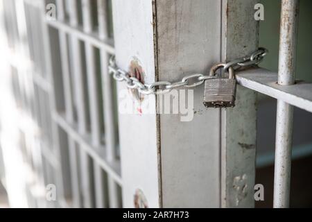 Door held close by a metal lock and chain Stock Photo