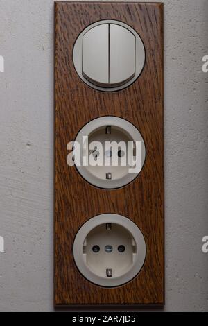 Electric double socket European standard and double switch with a wooden trim handmade. Vintage interior design in the loft style Stock Photo