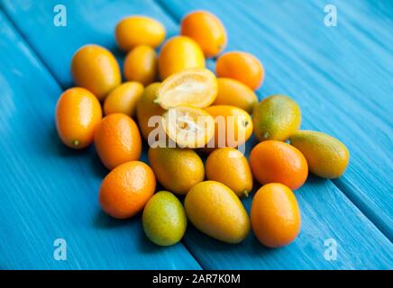 Kumquat on a blue background. Bright orange citrus fruits Stock Photo
