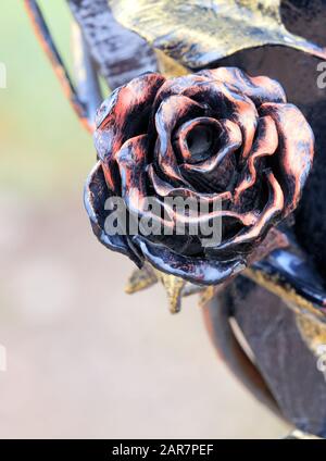 Red rose wrought iron and bronze, close-up with copy space. Stock Photo