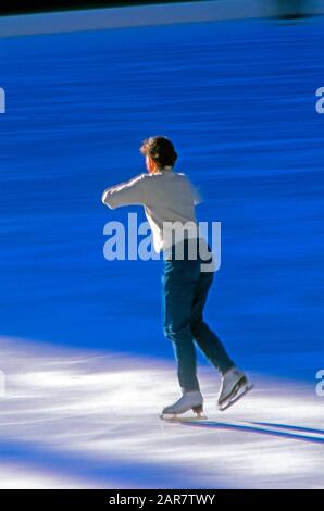 Amateur female ice figure skater practicing jumps on an outdoor ice rink