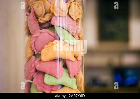 Raw colorful dumplings or vareniks in glass container, traditional Russian and Ukrainian food. Stock Photo