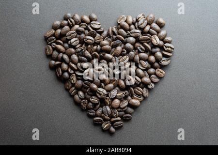 Heart shape made of roasted coffee beans on dark brown background Stock Photo