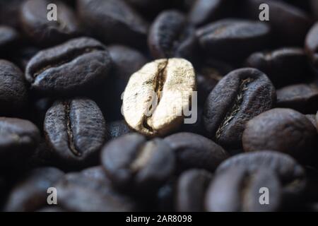 Close-up macro of the golden bean on roasted coffee background Stock Photo