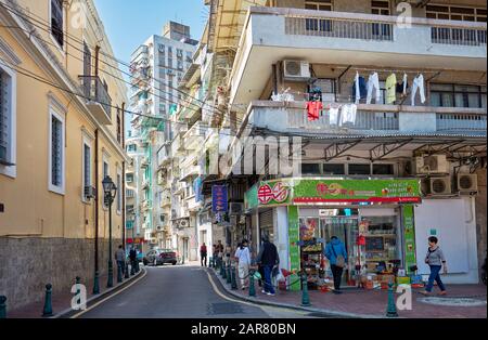 People walking in a narrow sidewalk in the historic centre of Macau, China. Stock Photo